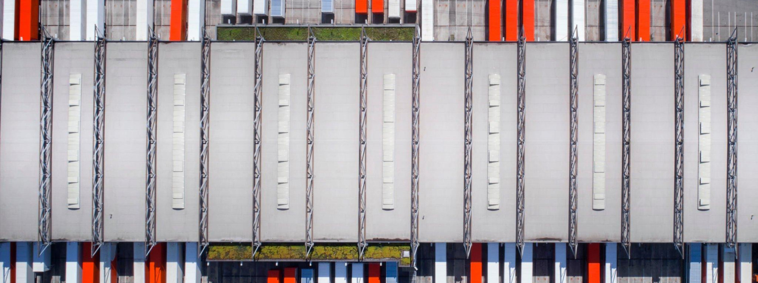 Overhead view of truck trailers parked side by side at warehouse loading bays.