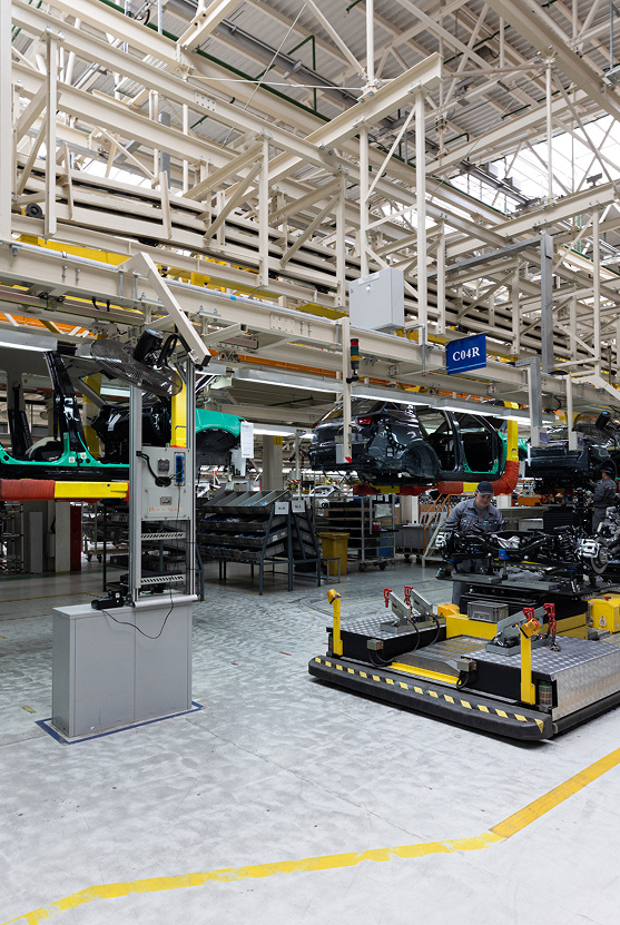 Industrial production floor with machinery beneath steel roof trusses.