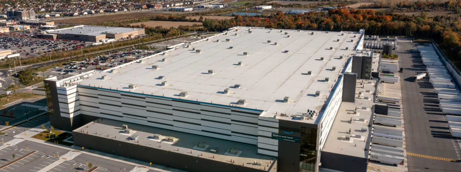 Aerial view of a multistorey logistics building with rooftop equipment and loading areas.